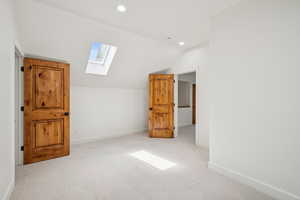 Bonus room featuring vaulted ceiling, a skylight, carpet flooring, and recessed lighting