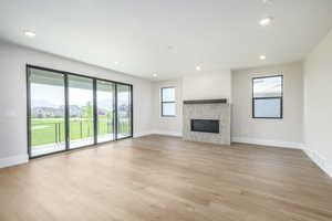 Unfurnished living room featuring light luxury vinyl flooring, a fireplace, and a residential view