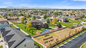 Aerial perspective of suburban area with a mountain backdrop and property parcel outlined