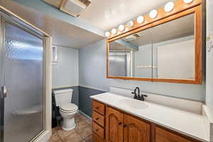 Bathroom featuring a shower stall, vanity, and light tile patterned flooring