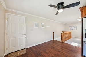 Entrance foyer featuring ornamental molding, wood finished floors, and ceiling fan
