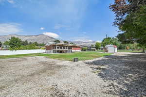 Rear view of property with a mountain view and an outbuilding