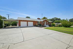 Ranch-style home with an attached garage, an attached carport, brick siding, and driveway