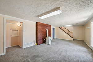 Carpeted Family room featuring a textured ceiling and stairs