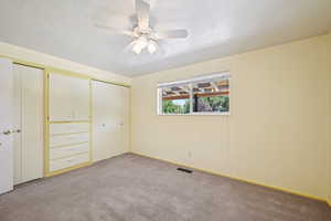 Unfurnished bedroom with light colored carpet, a closet, a ceiling fan, and a textured ceiling