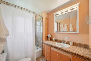 Full bathroom with shower / tub combo with curtain and vanity
