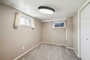 Bedroom featuring light colored carpet and a textured ceiling