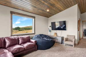Living room featuring lofted ceiling, wood ceiling, carpet flooring, and recessed lighting