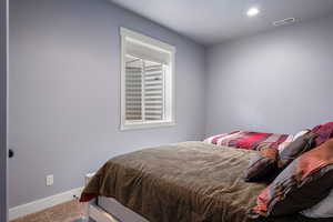 Carpeted bedroom with baseboards and recessed lighting