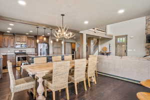 Dining room with dark wood-style flooring, recessed lighting, stairway, and a chandelier