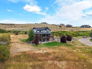 Rear view of property featuring a lawn and a patio