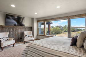 Bedroom with carpet, a textured ceiling, and recessed lighting