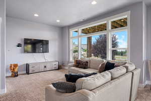 Living room featuring carpet flooring, recessed lighting, and a textured ceiling
