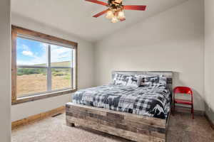 Bedroom with lofted ceiling, carpet floors, ceiling fan, and a textured ceiling