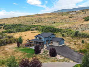 Aerial view of property and surrounding area featuring a mountain backdrop