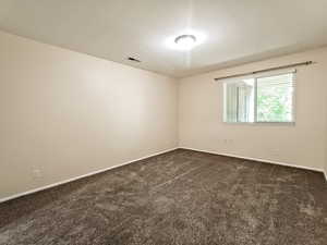 Primary bedroom window overlooking a secluded private balcony, bringing in natural light while maintaining a peaceful, tree-lined sense of privacy.