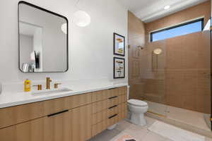 Bathroom with vanity, light tile patterned flooring, and tiled shower