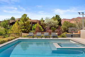 View of swimming pool featuring a patio, a mountain view, and a pool with connected hot tub