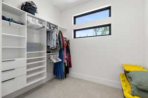Walk in closet featuring light colored carpet