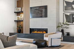 Living area with a glass covered fireplace and wood finished floors