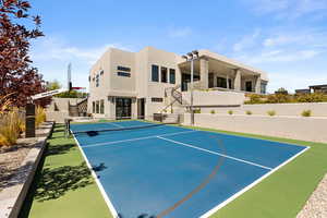 View of basketball court featuring stairs, a tennis court, and community basketball court