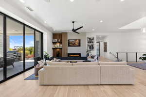 Living area with recessed lighting, light wood-style flooring, a tile fireplace, and ceiling fan