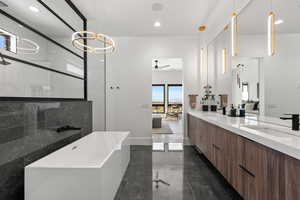 Full bath with connected bathroom, a shower stall, ceiling fan, double vanity, and recessed lighting