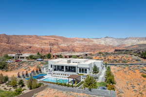 Back of house featuring a fenced backyard, a mountain view, a patio area, and a pool with connected hot tub