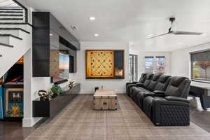 Living area with recessed lighting, stairway, and ceiling fan