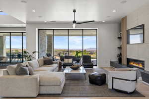 Living area with a tile fireplace, wood finished floors, recessed lighting, and a ceiling fan