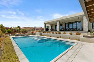 View of pool featuring a patio area, a mountain view, and a pool with connected hot tub