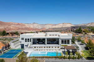 Back of house featuring a patio, stucco siding, a mountain view, a fenced backyard, and a pool with connected hot tub