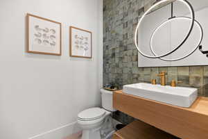 Bathroom featuring vanity, backsplash, and tile walls