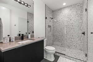 Bathroom featuring vanity, dark tile patterned flooring, a shower stall, and recessed lighting