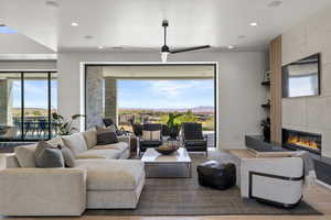 Living area featuring wood finished floors, a fireplace, recessed lighting, and ceiling fan
