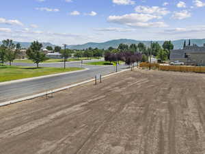 View of asphalt street featuring a mountain view and street lighting