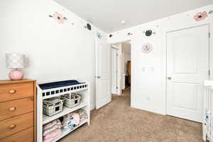 Bedroom featuring light colored carpet and baseboards