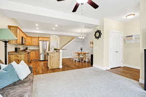 Kitchen featuring open floor plan, a ceiling fan, dark colored carpet, stainless steel appliances, and recessed lighting