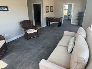 Clubhouse common area with dark colored carpet and baseboards