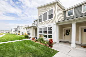 Property entrance with a lawn, covered porch, and a residential view