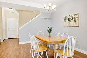 Dining area with wood finished floors and a chandelier