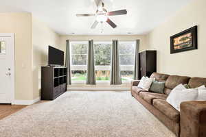 Living room with light colored carpet and ceiling fan
