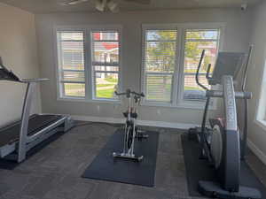 Clubhouse workout room featuring dark carpet and a ceiling fan