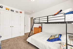 Bedroom with carpet, a closet, and attic access