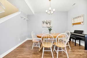 Dining area with wood finished floors and a chandelier