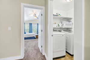 Laundry room with light colored carpet, independent washer and dryer, and ceiling fan