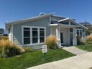 Bungalow featuring board and batten siding, a front lawn, and covered porch
