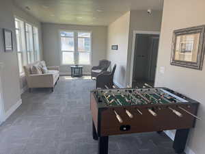 Clubhouse recreation room featuring baseboards and dark colored carpet