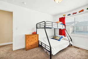 Bedroom featuring light carpet