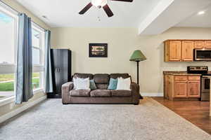 Living room with ceiling fan and dark carpet